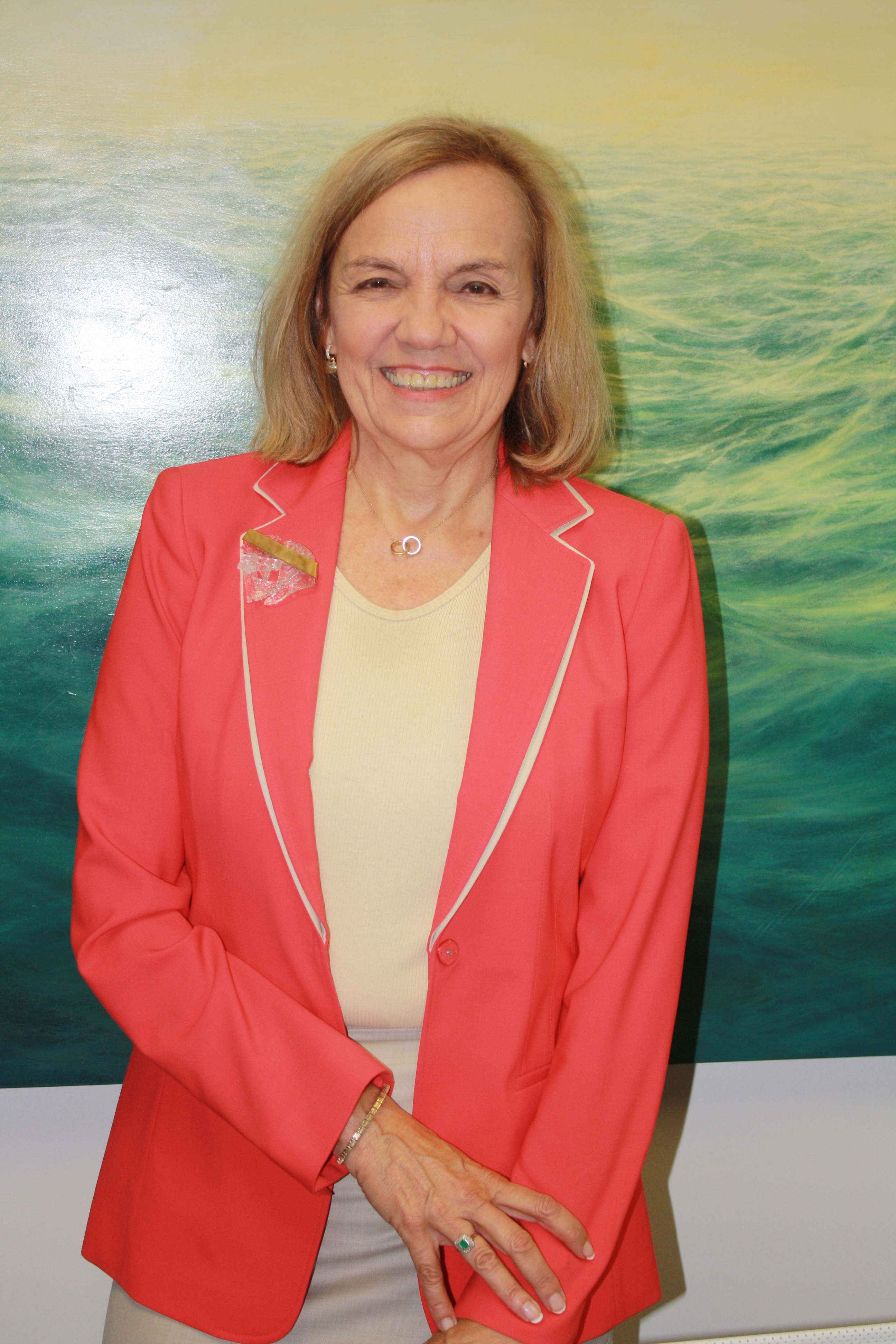 Cindy Miscikowski stands in front of wall with image of ocean waves