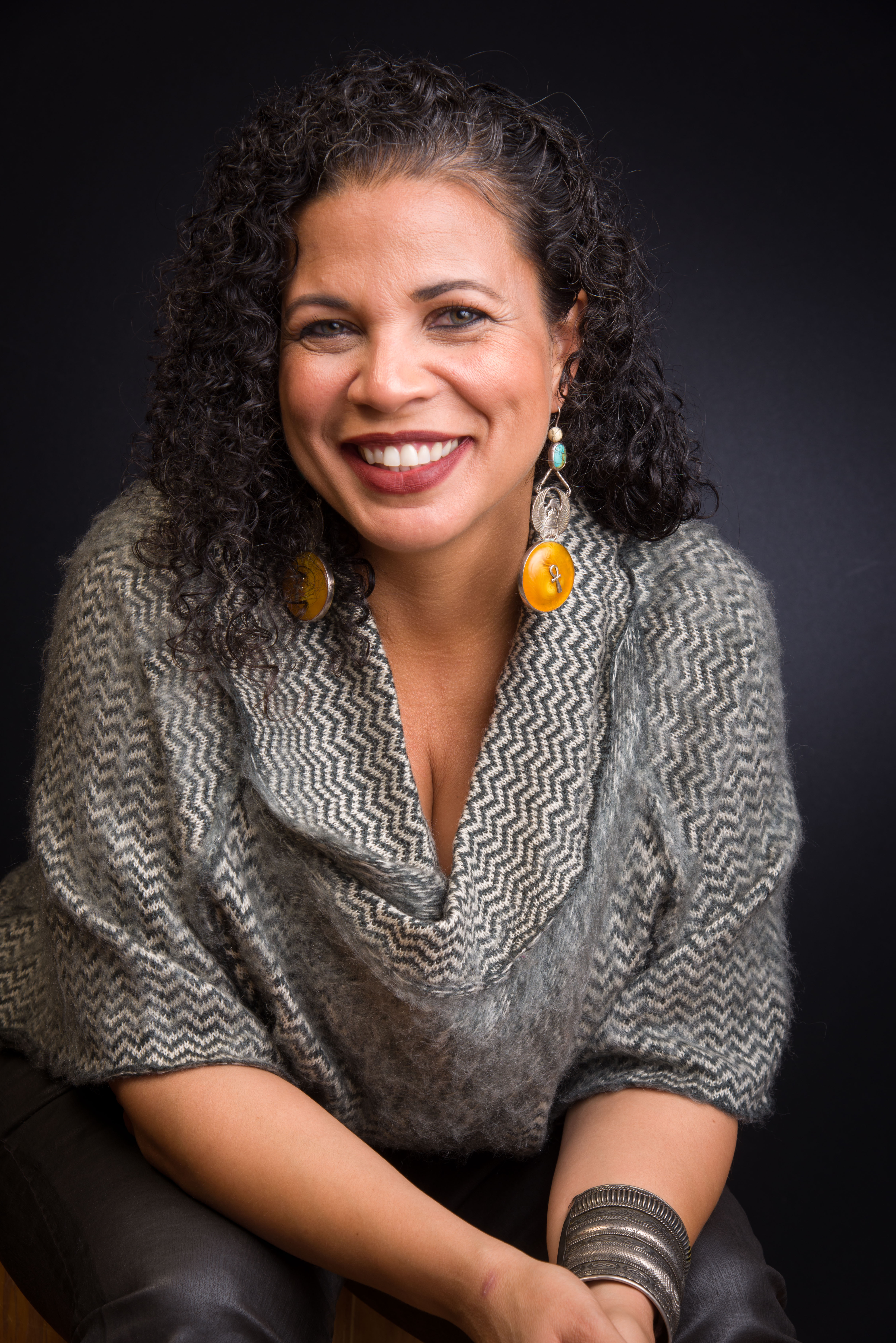 Dr. Melina Abdullah smiles in front of black backdrop