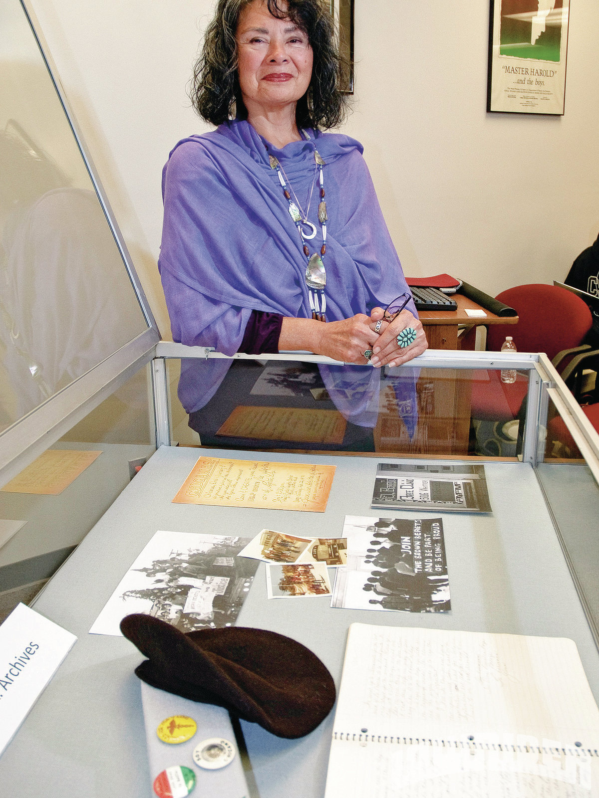Gloria Arrellanes stands in front of open case from exhibit