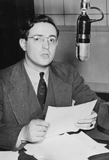Black and white photo of William Gottlieb with paper in hands, speaking into microphone